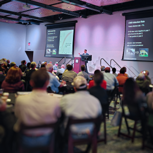 Dr. Gino D'Angelo giving a presentation about Chronic Wasting Disease to a group of attendees.